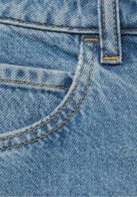 Gros plan d'une poche de jean en denim bleu avec des coutures orange visibles et une boucle de ceinture.