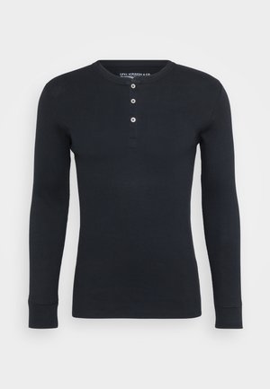 T-shirt à manches longues, col rond en coton côtelé marine avec patte de boutonnage à trois boutons et poignets ajustés. Design simple avec une texture subtile.