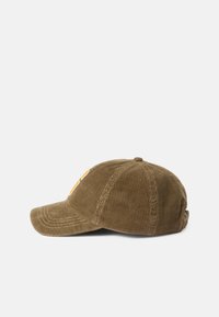 Gorra de béisbol de pana en verde oliva con tejido acanalado texturizado, visera curva y un logo bordado en naranja en el lateral.