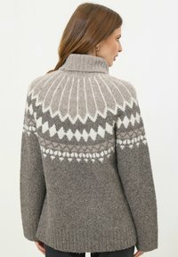 Maglione grigio a maglia con colletto alto, caratterizzato da un motivo geometrico bianco sul davanti e polsini a coste, realizzato in morbido misto lana.
