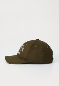Olivenfarget baseballcaps laget av bomull. Har broderte tekster og grafikk på forsiden, buet skjerm og ventilerte øyelet.