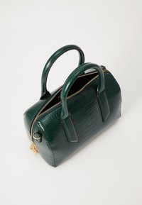 Sac à main en simili-crocodile vert avec une forme structurée, deux poignées, une fermeture éclair dorée et des accents noirs. Sa texture est lisse et brillante.
