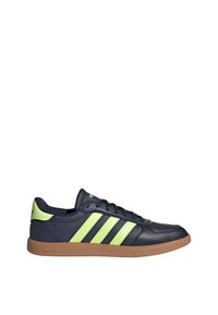 Black leather sneaker with three bright green stripes, gum sole, and padded collar. Features lace-up front and branded heel tab.