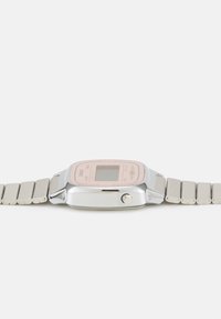 Montre numérique avec un boîtier rectangulaire en argent, un affichage rose et un bracelet en maillons métalliques argentés. Comprend une couronne ronde sur le côté droit.