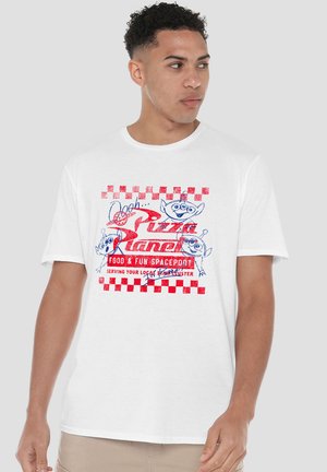 Man wearing white T-shirt with red and blue "Pizza Planet Food & Fun Spaceport" graphic and cartoon alien faces.