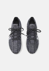 Zwart-witte gebreide sneakers met een gestructureerde bovenkant, ronde veters en een vlekkerige witte rubberen zool. Beschikt over een gevoerde tong en manchet.