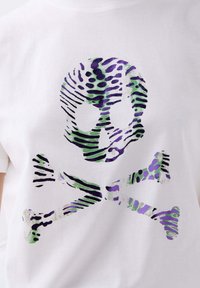 Hvid bomulds T-shirt med et lilla og grønt stiliseret skull and crossbones grafik med stribede detaljer.