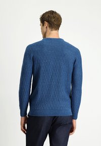 Niebieski dziergany sweter z fakturowanym wzorem. Posiada długie rękawy oraz okrągły dekolt, wykonany z miękkiej, prążkowanej tkaniny.