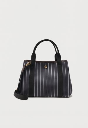 Μαύρη τσάντα χειρός με λευκές κάθετες ρίγες, μαύρες υφασμάτινες λαβές, λουρί ώμου και μικρή χρυσή λεπτομέρεια κουμπιού στο μπροστινό μέρος.
