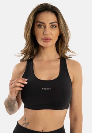 Musta urheilu crop-top, joka on valmistettu sileästä kankaasta. Siinä on avara kaula-aukko, ohuet hihnat ja pieni hopeinen "FREDDY"-logo keskellä.