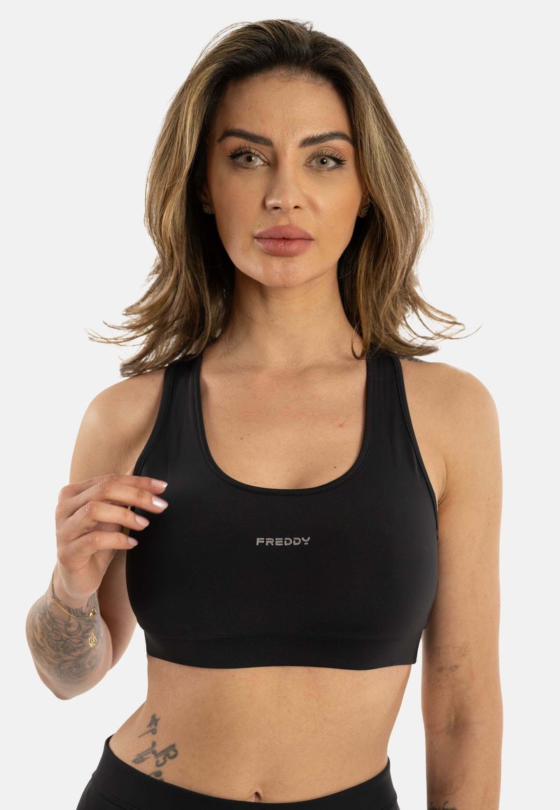 Svart idretts crop top laget av glatt stoff, med scoop-hals, tynne stropper og en liten sølv "FREDDY" logo i midten.