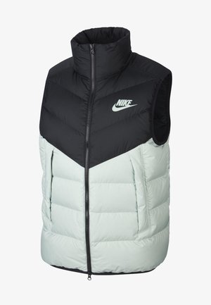 Nike ärmellose Steppweste mit einem schwarzen oberen Abschnitt, einem hellgrünen unteren Teil, einem Reißverschluss und einem auffälligen Nike-Logo auf der Brust.