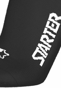 Sort tekstureret stof med store hvidstrikkede bogstaver, der staver "STARTER", og et hvidt stjernelogo på venstre side.