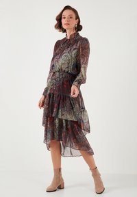 Stufenförmiges, paisleymusteriertes Kleid in dunklen Tönen von Rot, Grün und Marineblau; aus leichtem Stoff gefertigt, mit langen Ärmeln und einem Volantsaum.