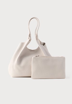 Beuteltasche aus cremefarbenem Leder mit strukturierter Oberfläche und zwei robusten Griffen, dazu passt ein Reißverschlusstäschchen.