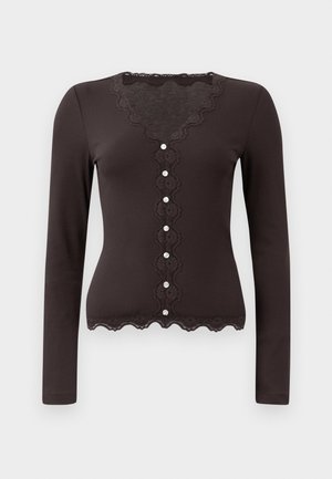 Svart langermet cardigan med bølget blondekant, V-hals og dekorative knapper foran. Ribbete tekstur gjennom hele plagget.