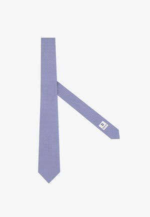 Corbata azul con un pequeño diseño circular repetitivo, que presenta una etiqueta blanca con el texto de la marca en el extremo más estrecho.