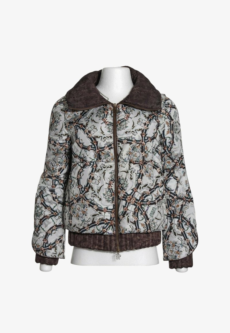 Veste courte matelassée avec grand col marron, motif floral et branches sur fond clair, fermeture éclair devant, ourlet et poignets côtelés.