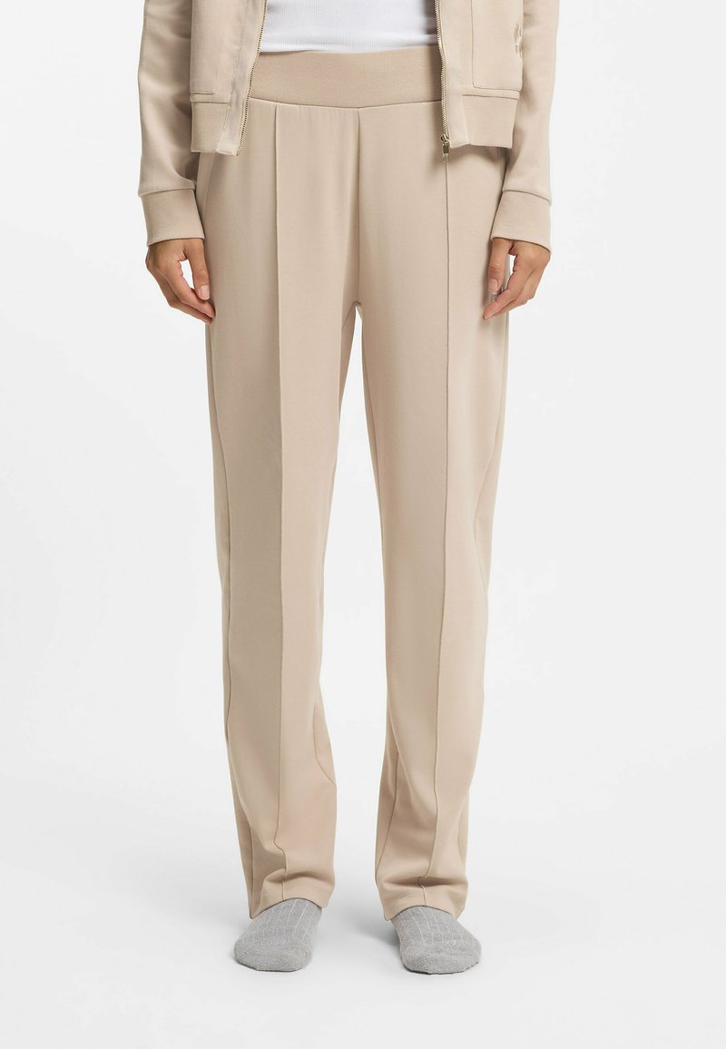 Beżowe spodnie o swobodnym kroju z szerokim paskiem i pionowymi paskami. Wykonane z miękkiego, elastycznego materiału, charakteryzujące się gładką fakturą i subtelnym połyskiem.