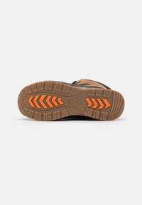 Suola di scarponi da trekking neri e marroni con un motivo di battistrada robusto, caratterizzata da accenti arancioni e gomma marrone testurizzata per una migliore aderenza.