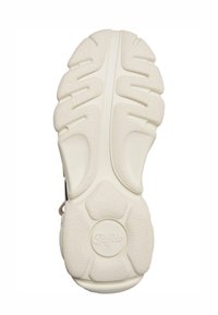 Semelle de sneaker blanche en caoutchouc texturé, avec des rainures profondes pour la traction et un détail de logo circulaire.