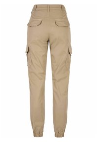 Pantalon cargo beige avec ourlet élastique, multiples poches latérales et tissu lisse et résistant. Conçu pour une coupe décontractée et une grande fonctionnalité.
