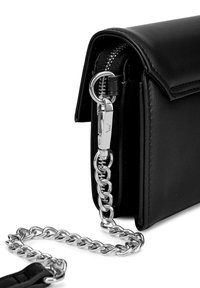 Schwarze Lederhandtasche mit Reißverschluss, ausgestattet mit einem silbernen Kettenriemen und metallischen Beschlägen. Glatte Textur mit verstärkten Kanten.