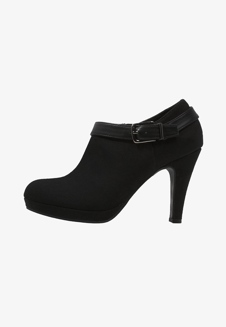 Bottine à talons hauts noire avec bout arrondi, semelle plateforme et bride en cuir décorative avec boucle argentée autour de la cheville.