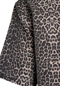 Tissu à motif léopard en beige et noir, doté d'une texture douce et de taches arrondies distinctes. Le design comprend un col structuré et des manches.