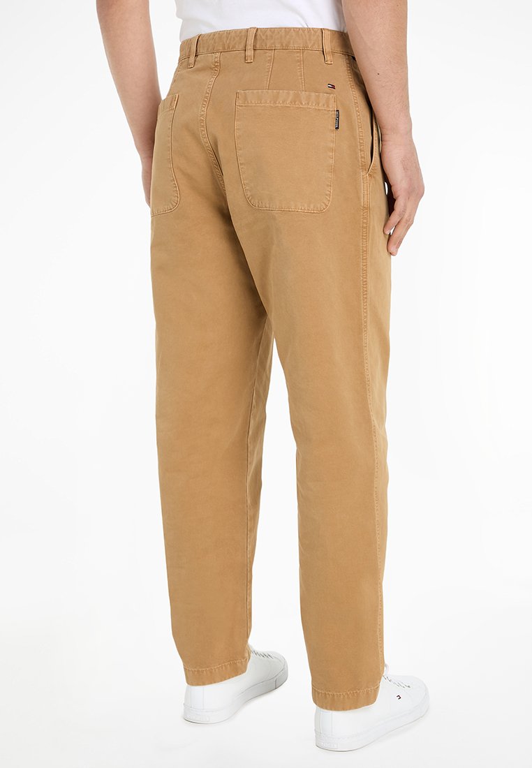 Pantaloni khaki con vestibilità dritta, realizzati in cotone. Presentano due tasche posteriori, una vita cucita e sneaker bianchi. Texture liscia.
