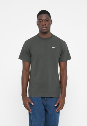 Dark gray cotton t-shirt with short sleeves, crew neckline, and embroidered "obey" logo on the left chest, worn with blue denim jeans.