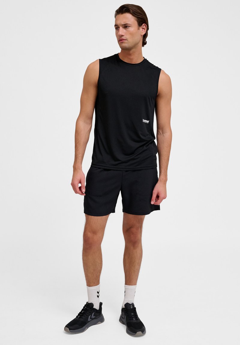 Zwarte mouwloze sportshirt met een ronde halslijn, gecombineerd met bijpassende zwarte shorts en zwarte sneakers. Eenvoudig ontwerp, zacht materiaal.