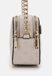 Piccola borsa a mano in rosa chiaro con motivi impressi, accessori in oro e una catena robusta come tracolla. Presenta doppi cursori e dettagli neri.