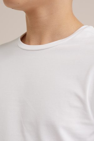 Vit kortärmad t-shirt med rund halsringning, slät bomullstyg, figursydd silhuett, subtil textur, inga synliga mönster eller grafik.