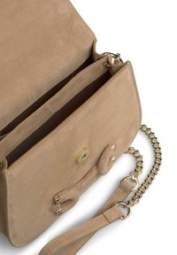 Geantă crossbody din suede bej cu o curea din lanț aurie. Dispune de o închidere cu clapetă și un nasture rotund, precum și două compartimente interne. Textură netedă.