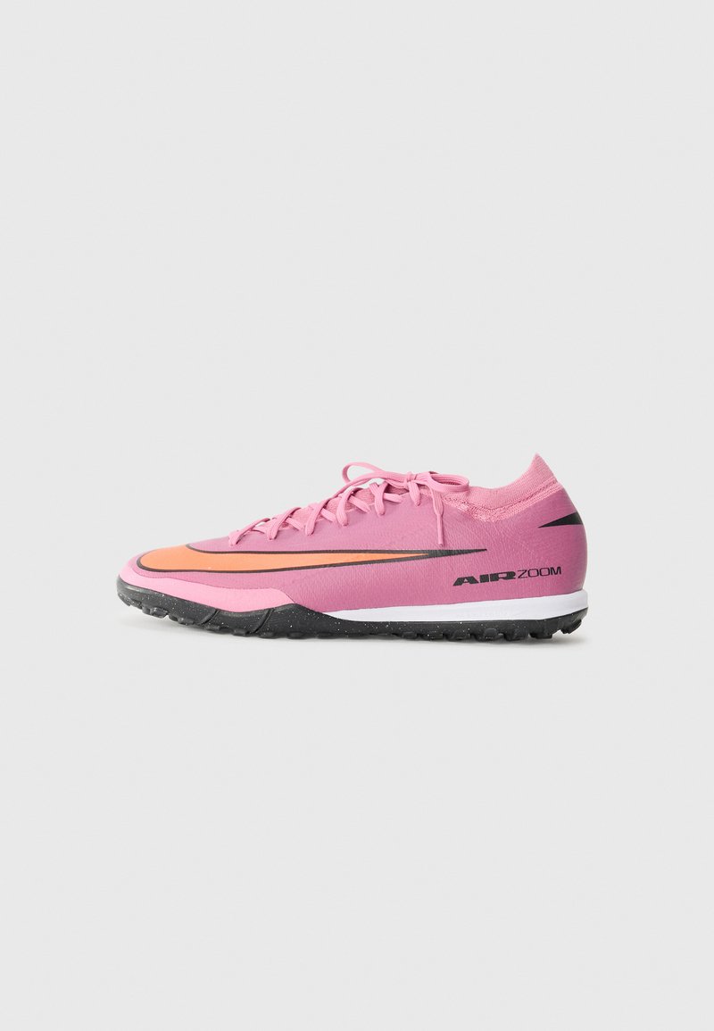 Light pink athletic shoe with orange and black accents. Features a textured upper, flat laces, and a rubberized sole with a slightly raised heel.