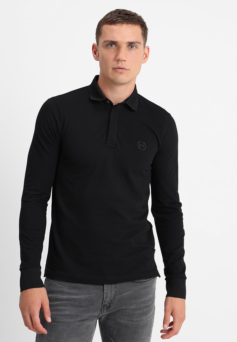 Polo a maniche lunghe nera con colletto e un logo discreto sul petto. Realizzato in un tessuto liscio e leggero.
