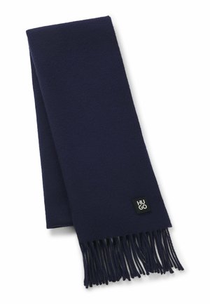 Navy blue wool scarf with fringed edges, featuring a small black logo tag labeled "HUGO" near one end. Soft texture, rectangular shape.