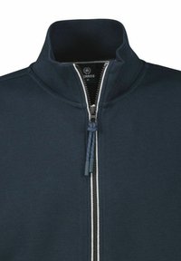 Marine blauwe ritsjack met een staande kraag, gekenmerkt door een gestructureerde stof, contrasterende witte ritssluiting en een blauwe trekkoord aan de rits.
