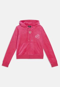 Felpa con zip in velluto rosa, caratterizzata da un tirante a forma di cuore, tasche frontali e un logo decorativo con applicazioni sul petto.