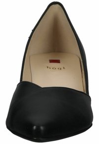 Svart läder högklackad sko med spetsig tå och en slät yta. Har en rundad front söm och en beige inredning. Varumärkeslogotyp är närvarande.