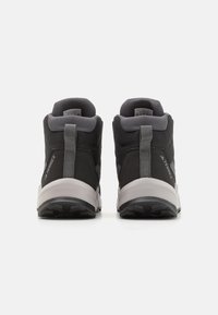 Schwarze Mid-Top-Sportschuhe mit Obermaterial aus Mesh und Synthetik, gepolsterter Schuhkragen, grauen Akzenten und Gummisohle mit rutschfestem Muster.