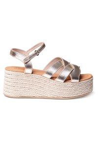 Sandalias en cuña de color plateado metálico con plataforma de cuerda trenzada, correas ajustables en el tobillo y tiras entrecruzadas sobre los dedos.