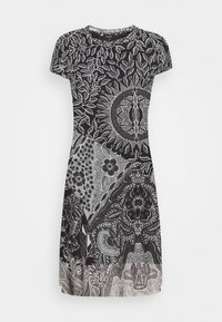 Robe courte noir et blanc à manches courtes avec des motifs floraux et géométriques complexes couvrant le tissu.