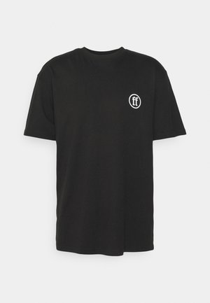 Tricou din bumbac negru cu mâneci scurte, guler rotund și un logo circular alb ce prezintă un "ff" stilizat în zona stângă a pieptului.