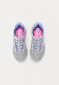 Zapatillas deportivas grises con parte superior de malla, cordones elásticos en azul y rosa, cuello acolchado y suela texturizada. Ideales para uso casual y facilidad de uso.
