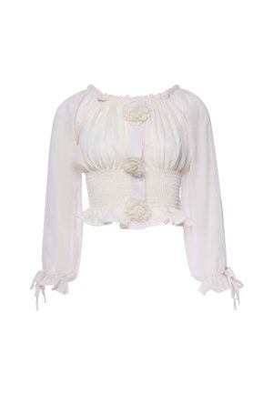 White long-sleeve cropped blouse with ruched bodice, smocked waist, floral fabric buttons down front, and ties at sleeve cuffs.
