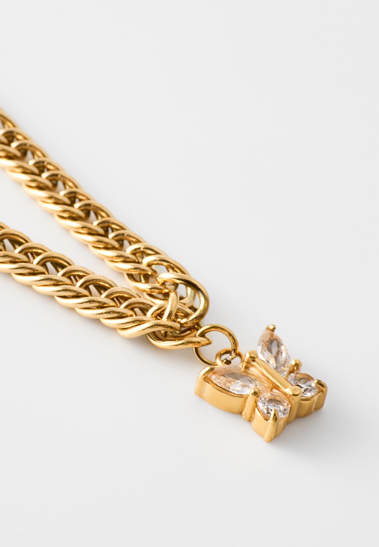 Goldfarbener Anhänger mit einer Schmetterlingskette, versehen mit klaren Edelsteinen, filigranen Details und einer glatten, polierten Oberfläche.