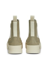 Sneaker alte in camoscio tan con pannelli laterali elastici bianchi e suole in gomma crema a contrasto. Presenta un'etichetta con il logo sul tallone posteriore.