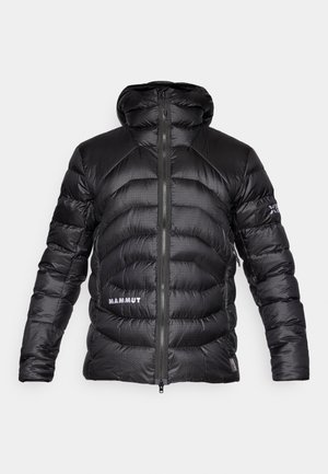 Juodas pūkinis džemperis su gobtuvu, turintis siuvinėtų sekcijų ir priekinį užtrauktuką. Baltas „MAMMUT“ logotipas kairėje pusėje. Lygus tekst�ūra.